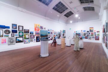 Various artworks. The artworks of display are small black and red ink drawings of human figure and face, large blow up of fanzine cover, and a cluster of drawings and patterns on brightly coloured paper. The works were included in the exhibition Social Club.